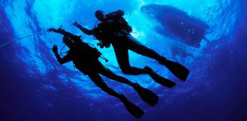 Zwei Taucher gehen Tieftauchen. Two divers conducting a deep dive