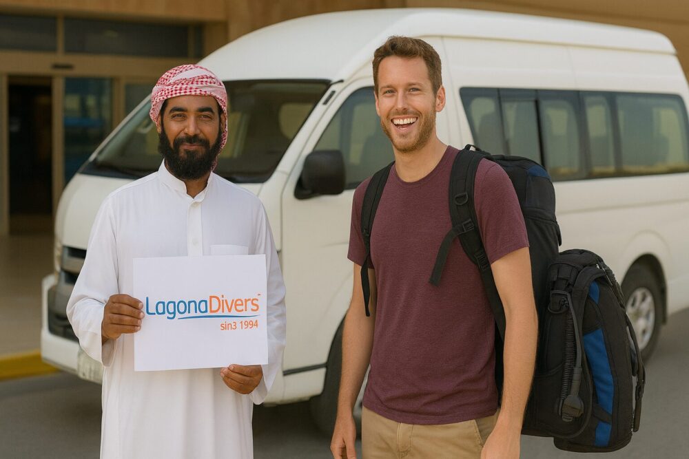 Lachender Taucher wird am Flughafen von einem Beduinen mit Lagona Divers Abholschild vor einem weißen Minibus empfangen